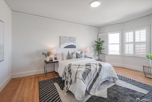 bedroom featuring light wood-style flooring and baseboards