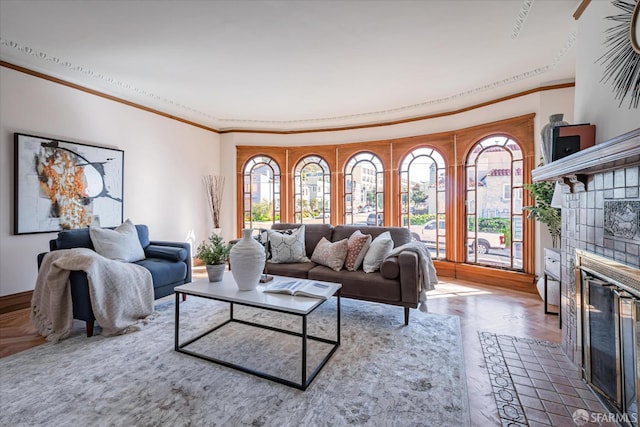 living room featuring crown molding and a tiled fireplace