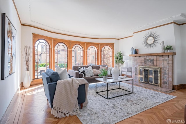 living room featuring baseboards, a tile fireplace, and crown molding