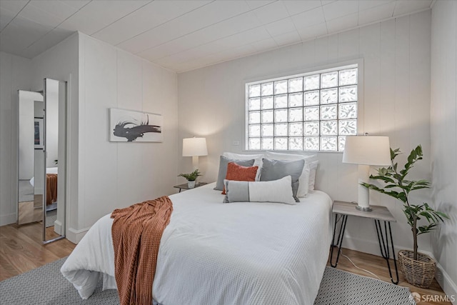 bedroom featuring baseboards and wood finished floors