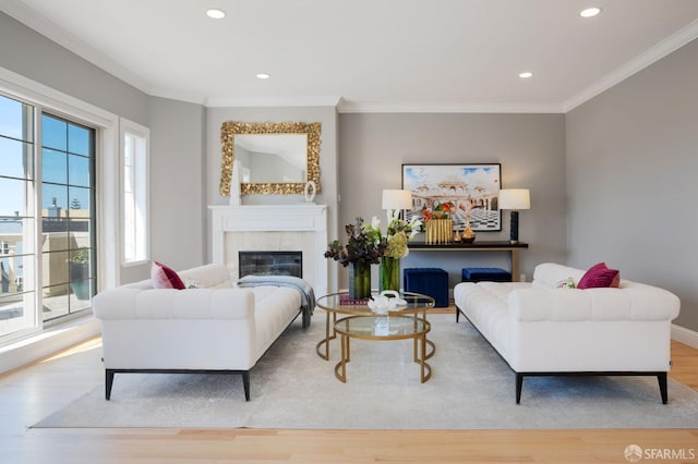 living room featuring light hardwood / wood-style flooring, a fireplace, and ornamental molding