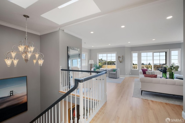 hallway featuring a notable chandelier, crown molding, and light hardwood / wood-style flooring