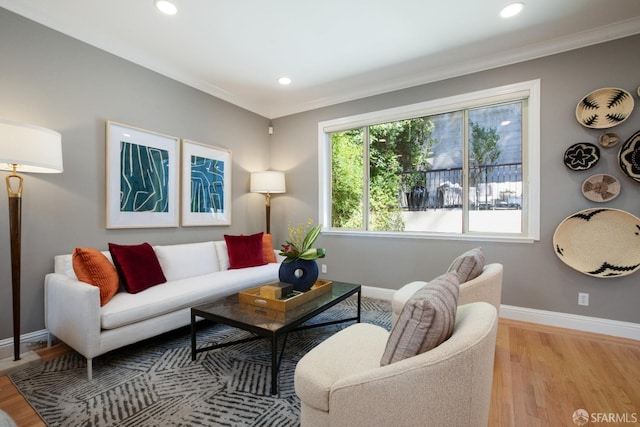 living room featuring light wood-type flooring and crown molding