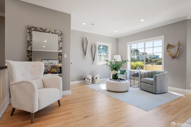 living area featuring ornamental molding and light wood-type flooring