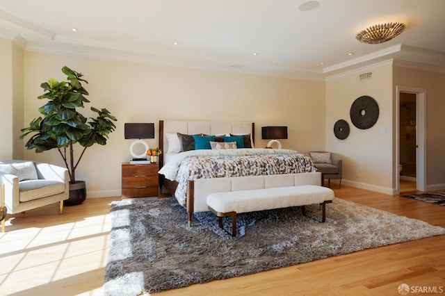 bedroom with ornamental molding and light wood-type flooring