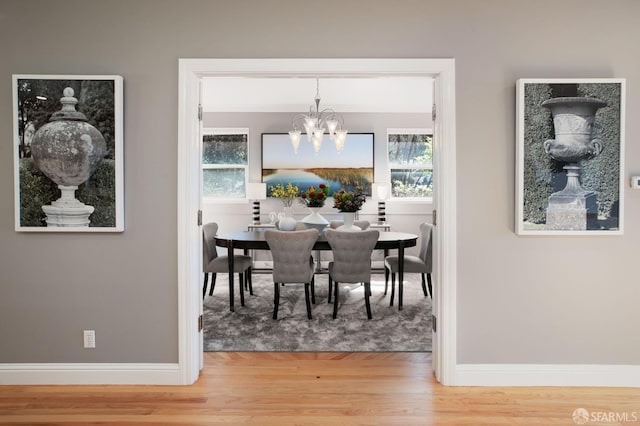 dining space featuring hardwood / wood-style floors and an inviting chandelier