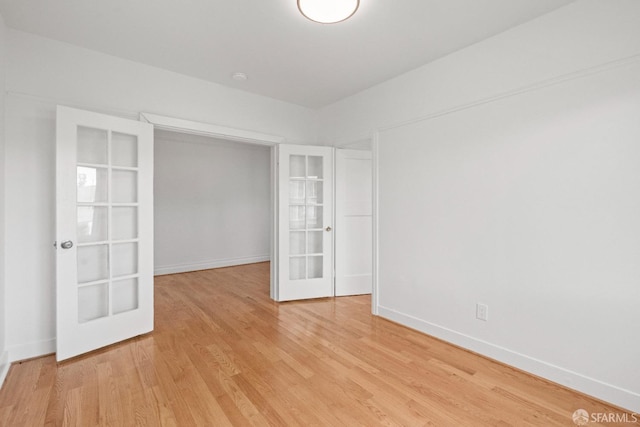 unfurnished room with french doors and light wood-type flooring