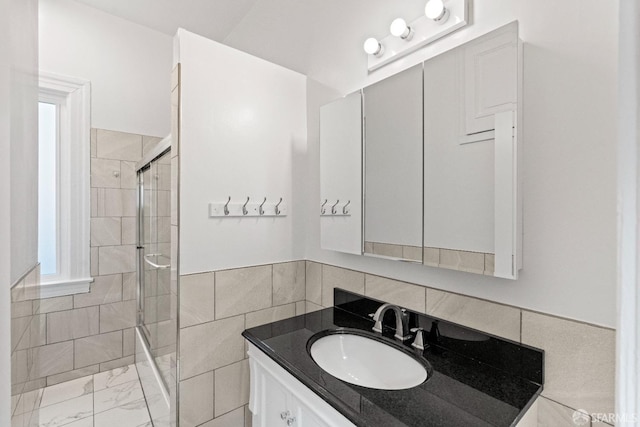 bathroom with vanity, tile walls, and a tile shower