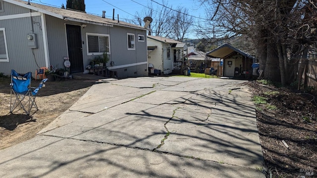 back of property with driveway and crawl space