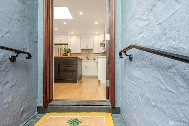 interior space with wood-type flooring, sink, and a skylight