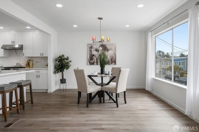 dining space with a notable chandelier and light hardwood / wood-style floors