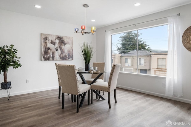 dining room with hardwood / wood-style floors and an inviting chandelier