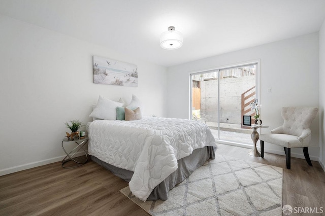 bedroom featuring wood-type flooring and access to exterior