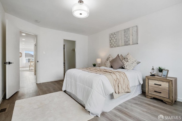 bedroom with hardwood / wood-style floors, a closet, and a spacious closet