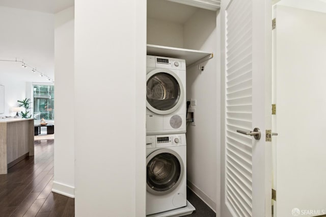 washroom featuring stacked washing maching and dryer and dark hardwood / wood-style flooring