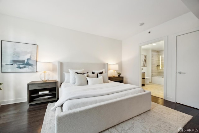 bedroom with dark hardwood / wood-style flooring and connected bathroom