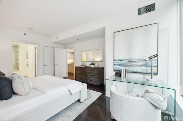 bedroom with dark hardwood / wood-style floors and ensuite bath