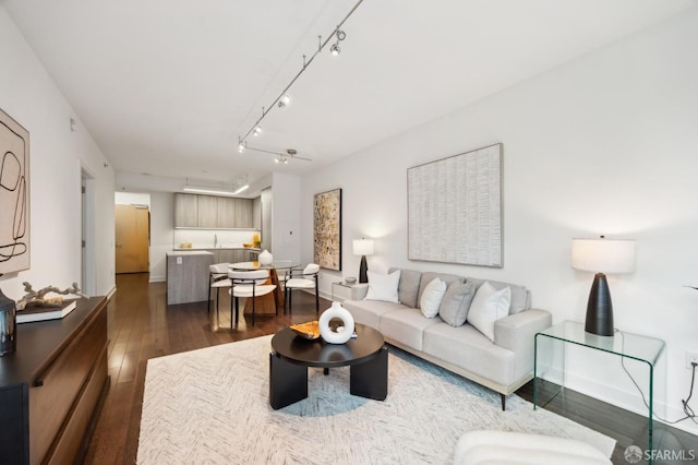 living room with dark wood-type flooring and track lighting