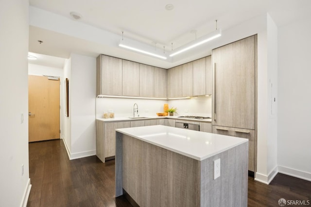 kitchen featuring a kitchen island, light brown cabinetry, sink, dark hardwood / wood-style floors, and gas cooktop