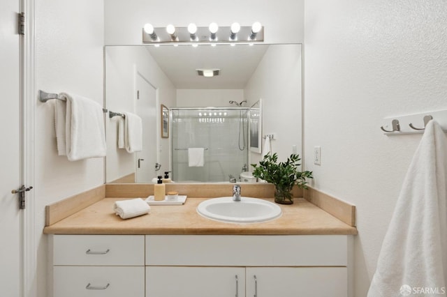 full bathroom with visible vents, a shower stall, and vanity