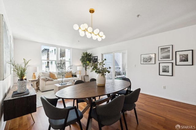 dining space with a chandelier, baseboards, and wood finished floors