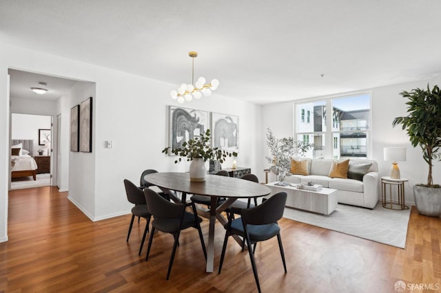 dining area with a chandelier, baseboards, and wood finished floors