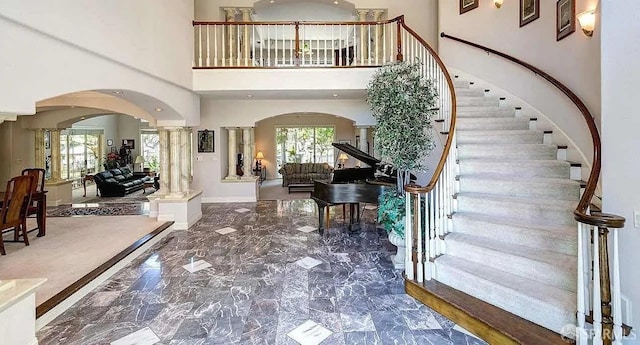 2220 Sunset Pt, Discovery Bay, CA 94505 - foyer with arched walkways, ornate columns, a high ceiling, marble tiled floors, and stairs