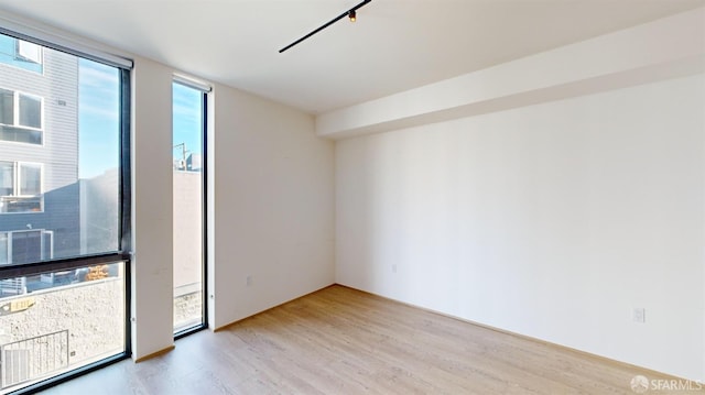 spare room with light hardwood / wood-style floors and expansive windows