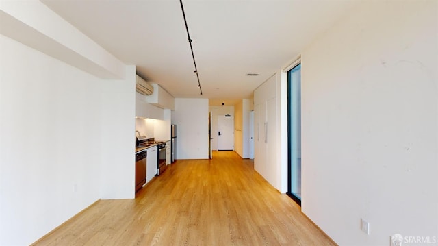 hall with light wood-type flooring and a wall unit AC