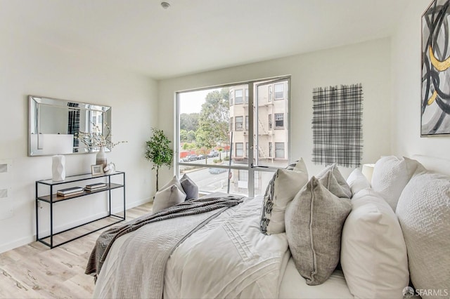 bedroom with access to exterior and light wood-type flooring