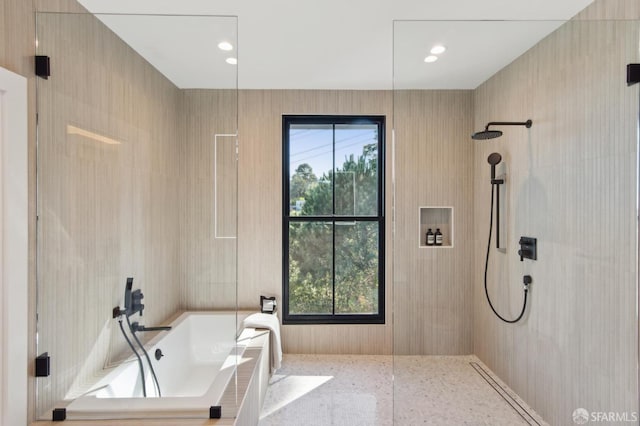 bathroom with a healthy amount of sunlight, a garden tub, and a walk in shower