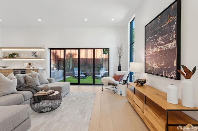 living room featuring light wood-style flooring, a wealth of natural light, and recessed lighting