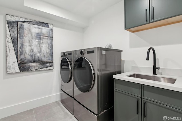 laundry room featuring cabinet space, a sink, washing machine and clothes dryer, and light tile patterned floors