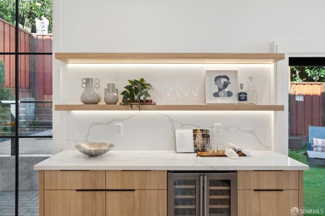 bar with beverage cooler, a dry bar, brick floor, and a healthy amount of sunlight