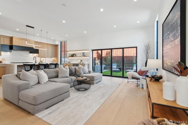 living area featuring light wood-type flooring and recessed lighting