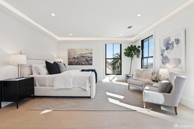 bedroom featuring light wood-type flooring, a tray ceiling, and recessed lighting