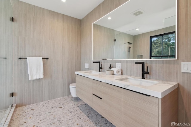 bathroom with visible vents, double vanity, a sink, and toilet