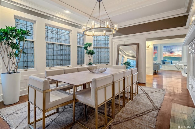 dining area featuring ornamental molding, hardwood / wood-style floors, and a chandelier