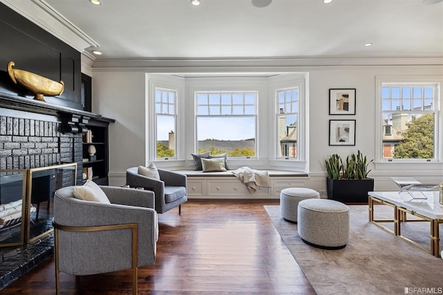 sitting room with dark wood-type flooring and ornamental molding