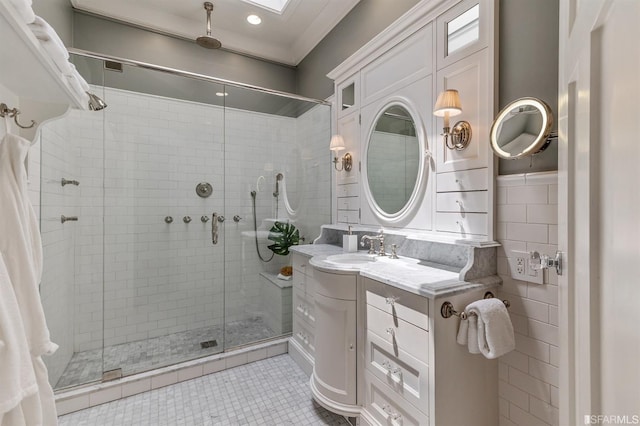 bathroom with vanity, an enclosed shower, tile patterned flooring, and tile walls