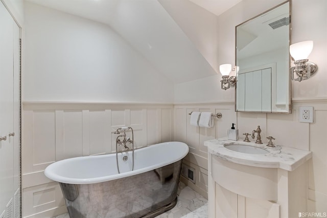 bathroom with vanity, a tub to relax in, and vaulted ceiling