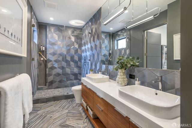 full bath with a walk in shower, double vanity, a sink, and tile walls