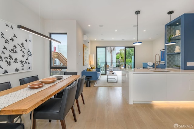 dining room with light wood-type flooring, a wall mounted air conditioner, and recessed lighting