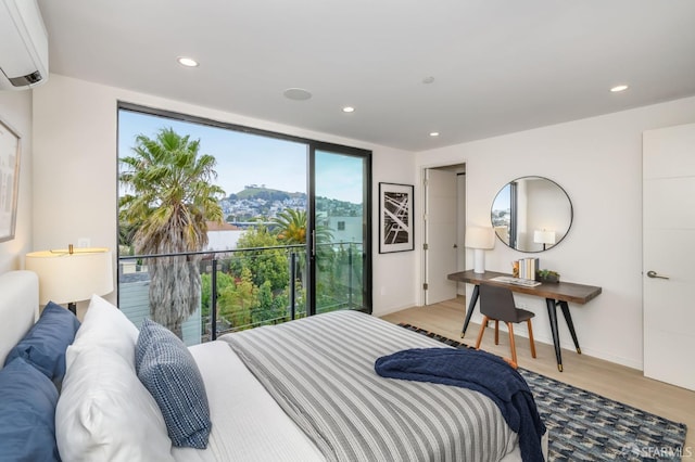 bedroom with recessed lighting, an AC wall unit, and light wood finished floors