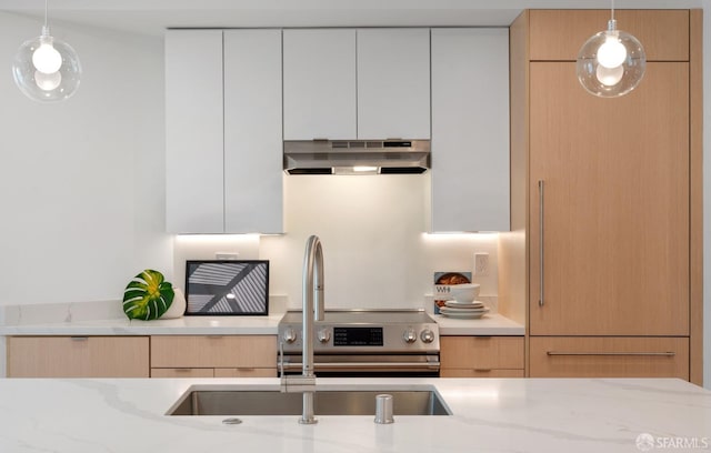 kitchen with white cabinetry, light brown cabinetry, decorative light fixtures, and light stone countertops