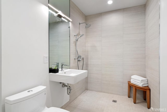 bathroom featuring sink, toilet, and tiled shower