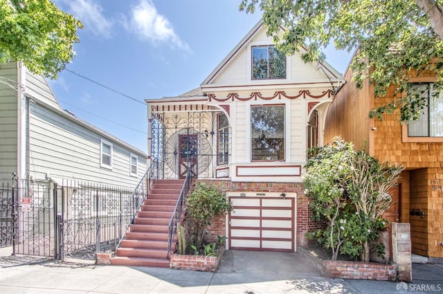 2567 Bryant St, San Francisco, CA 94110 - view of front facade with driveway, a garage, a gate, and stairway