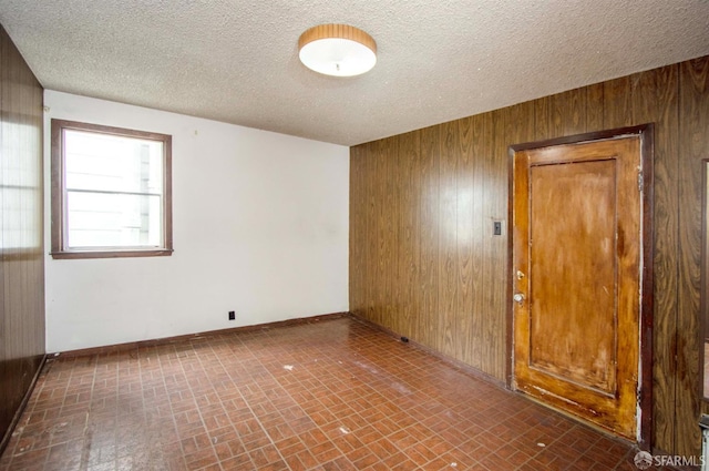 2567 Bryant St, San Francisco, CA 94110 - empty room with brick patterned floors, wood walls, and a textured ceiling