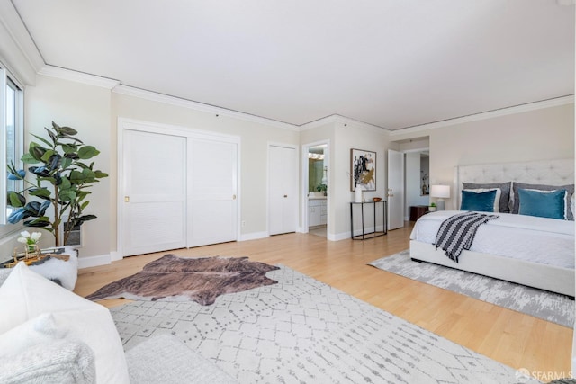 bedroom featuring light wood-style flooring, connected bathroom, baseboards, and crown molding