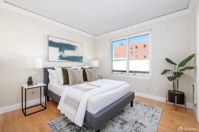 bedroom featuring crown molding, baseboards, and wood finished floors